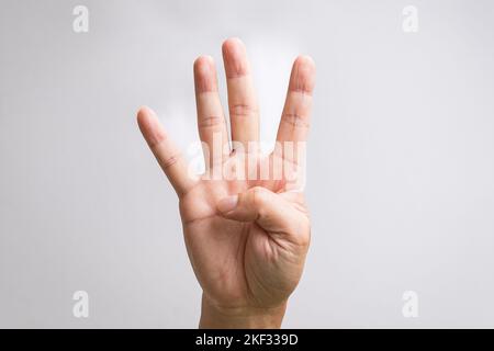 Main montrant quatre doigts. Sur fond blanc. Banque D'Images