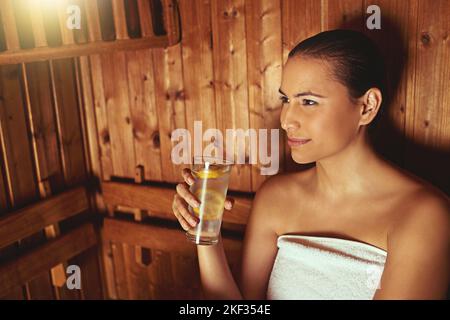 Un peu de silence au sauna. Une jeune femme se détend au sauna dans un spa. Banque D'Images