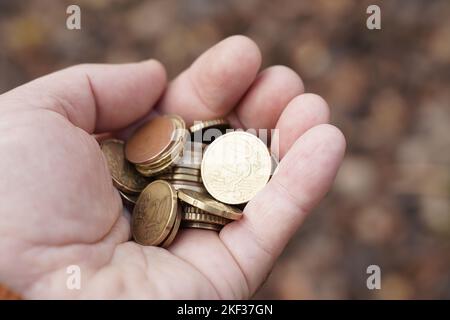 Concept économique et commercial. L'homme a une poignée de pièces dans sa main. Banque D'Images