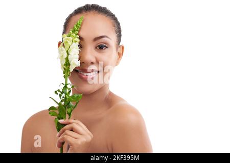 Shes l'image de la beauté naturelle. Photo studio d'une jeune femme posant avec des plantes sur un fond blanc. Banque D'Images
