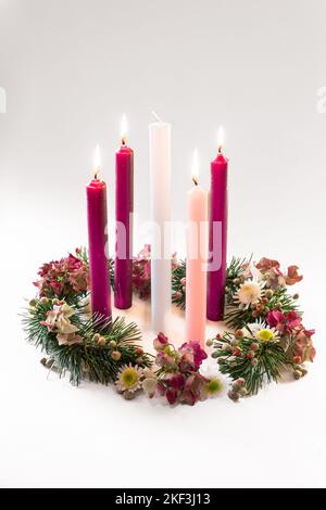 3 bougies violettes, 1 roses et une bougie blanche sur la couronne de l'avent chrétien décorée et ornée, isolée, quatrième semaine de l'avent Banque D'Images