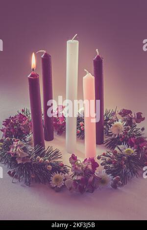 3 bougies violettes, 1 roses et une bougie blanche sur la couronne de l'avent chrétien décorée et ornée, isolée, première semaine de l'avent Banque D'Images