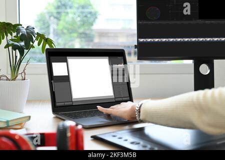 Prise de vue rognée d'une femme indépendante travaillant à l'édition de vidéos avec un ordinateur professionnel sur son poste de travail Banque D'Images