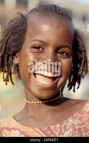 Burkina Faso, Ouagadougou fille riant avec le style traditionnel des cheveux. Banque D'Images