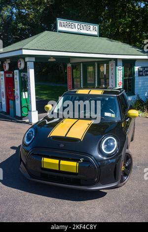 Warren Center, PA, USA - 24 sept, 2022: Un mini Cooper se 2023 noir et jaune, un véhicule électrique, est photographié près d'une station-service d'époque localiser Banque D'Images