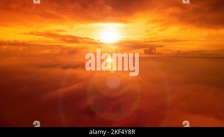 Un coucher de soleil rouge brûlant au-dessus de la mer et des nuages le drone vole au-dessus de nuages brumeux et moelleux. Résumé nature aérienne été océan coucher de soleil mer et ciel Banque D'Images