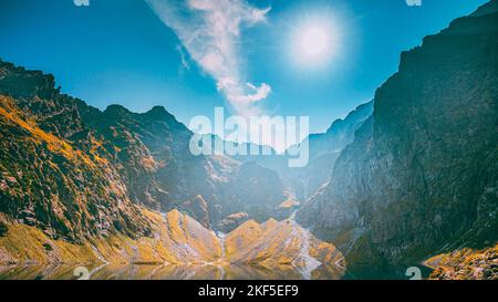 Parc national de Tatra, Pologne. Calme lac Czarny Staw sous Rysy et paysage des montagnes d'été. Soleil avec des rayons de soleil au-dessus de la belle vue panoramique de Banque D'Images