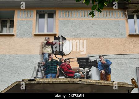 Murale représentant une équipe de cinéma avec Claude Lelouch comme réalisateur et Bernard Giraaudeau comme 'clap', sur la façade du cinéma Vox, Chamonix, France Banque D'Images