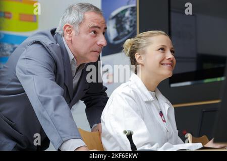 mentor et jeune femme travaillant en atelier Banque D'Images