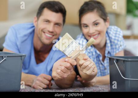 portrait d'un couple montrant des outils de peinture Banque D'Images