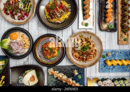Fusion gastronomique entre le Japon et le Pérou avec ceviche, pain Bao, ragoût de crevettes, nouilles udon sautées aux crevettes et autres recettes typiques et colorées W Banque D'Images