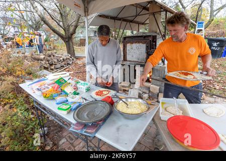 Detroit, Michigan - deux hommes font des pizzas à l'aide d'un four à bois extérieur lors d'un festival d'automne sur le côté est de Detroit. Banque D'Images