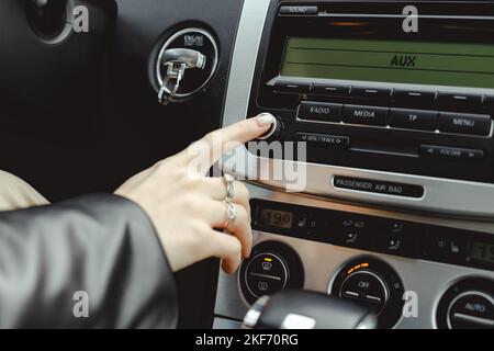 Femme active la radio multimédia dans une voiture Banque D'Images