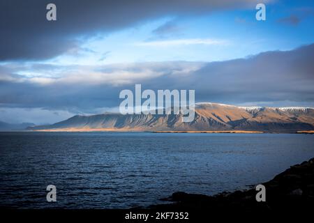 Paysage avec le mont Esja et la côte atlantique de l'océan à Reykjavik, Islande. Pas de personne, ciel bleu nuageux. Banque D'Images