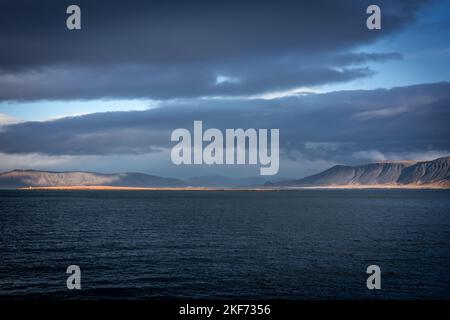 Paysage avec le mont Esja et la côte atlantique de l'océan à Reykjavik, Islande. Pas de personne, ciel bleu nuageux. Banque D'Images