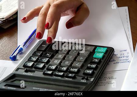 woman effectue un calcul sur une calculatrice Banque D'Images
