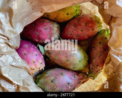 Cactus poire pickly coloré frais mûr entier et couper les fruits dans un sac de papier brun. Banque D'Images