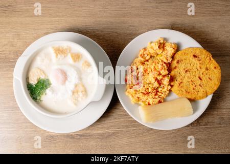 Vue de dessus du bouillon de lait de changua colombien avec des œufs et une assiette d'œufs brouillés sur le côté Banque D'Images