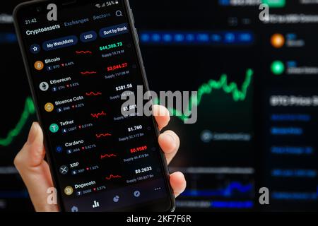 Ukraine, Odessa - octobre 9 2021 : main tenant mobile avec l'application CoinMarketCap fonctionnant sur l'écran de smartphone avec la liste des prix de crypto-monnaie actuels, Banque D'Images