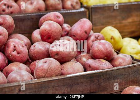 Pommes de terre rouges biologiques fraîches empilées dans un panier à faible profondeur de champ Banque D'Images