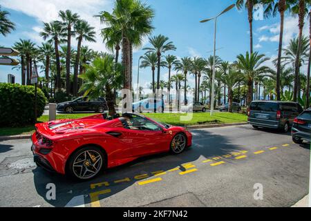 09.02.2022 Cannes , France. Rouge Ferrari 458 sur la Croisette dans une nature fantastique avec des palmiers en été! Banque D'Images