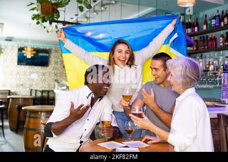 Heureux fans célébrant la victoire de l'équipe ukrainienne au bar Banque D'Images