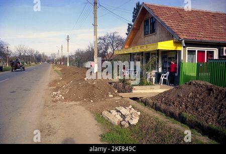 Snagov, comté d'Ilfov, Roumanie, env. 2000. Une tranchée creusée sur le bord de la route pour atteindre la conduite d'eau ou d'égout. Banque D'Images