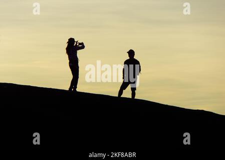 Une femme thaïlandaise prenant des photos avec son téléphone lors d'une aventure de voyage avec un ami à Three Whale Rock, Bueng Kan, Thaïlande. Banque D'Images
