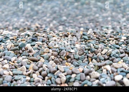 L'eau propre en cristal lave les cailloux qui se trouvent sur la plage de la mer. Les cailloux mouillés se trouvent près du bord de l'eau, attendant que les vagues se roulent de près Banque D'Images