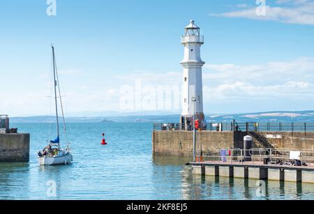 Bateau passant par le phare de Newhaven sur un chaud ensoleillé, paisible jour d'été, mer et ciel bleu calme, les gens se tiennent et de pêcher de la jetée, des vues claires de c Banque D'Images