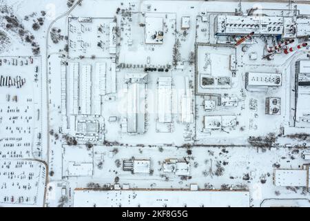 vue aérienne en haut de la zone industrielle enneigée de la ville avec les bâtiments de fabrication et les entrepôts Banque D'Images