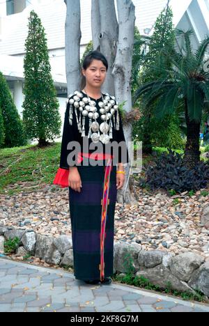 Une jeune femme Kachin ou Jingpo non identifiée vêtie d'une robe traditionnelle porte un headdress traditionnel montrant , au cours d'une représentation culturelle nationale. Banque D'Images