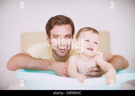 HES toujours là pour s'occuper d'elle. Un jeune père se liant à sa fille au moment du bain. Banque D'Images