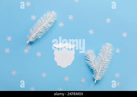 Barbe de Noël en papier, branches de Noël et flocons de neige sur fond bleu Banque D'Images