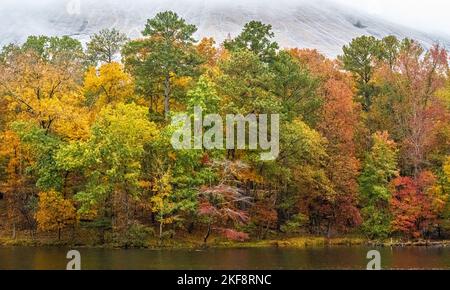 Vue d'automne sur le feuillage coloré et la brume couverte de Stone Mountain depuis un sentier au bord du lac au Stone Mountain Park à Atlanta, Géorgie. (ÉTATS-UNIS) Banque D'Images