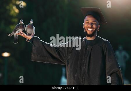 Portrait d'étudiant, diplômé et pigeon avec un sourire, un chapeau et un manteau pour la remise des diplômes, la célébration et la réalisation en plein air dans le parc. Université, collège ou Banque D'Images