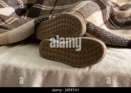 une fille de baskets dort sur un lit à la maison, ses pieds sont dans des chaussures sur le lit, trop paresseux pour enlever ses chaussures Banque D'Images