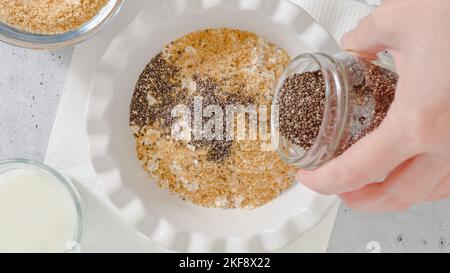 Femme préparant le petit déjeuner. Flocons d'avoine à base d'avoine entière, de farine de lin, de graines de Chia et de lait. Vue rapprochée du dessus Banque D'Images