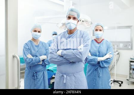 Assurez-vous d'obtenir le traitement dont vous avez besoin. Portrait d'une équipe de chirurgiens médicaux portant leurs exfoliants d'hôpital et leurs masques faciaux. Banque D'Images