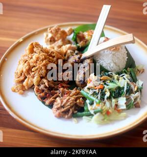 Nasi Campur Bali. Plat balinais de riz cuit à la vapeur avec variété de plats d'accompagnement Banque D'Images