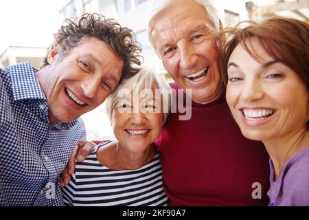 Vivre, aimer, rire. Portrait d'un couple senior debout à l'extérieur avec leurs enfants. Banque D'Images