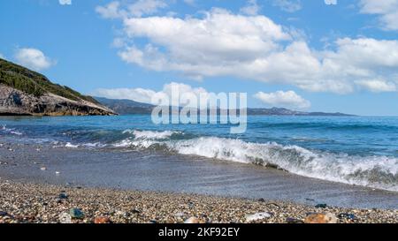 Vagues sur une plage de rochers en Corse - France sous un grand ciel bleu Banque D'Images