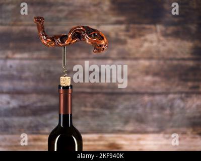 Bouteille de vin avec ancien tire-bouchon en bois vintage sur fond en bois avec espace de copie Banque D'Images