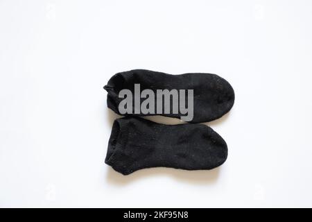 chaussettes sales noires sur fond blanc, chaussettes usées Banque D'Images