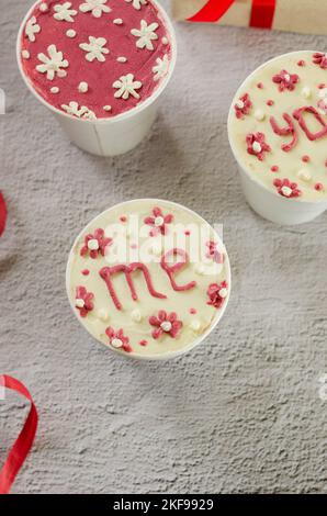 mini-gâteau fait maison dans des tasses de café blanches jetables, nouvelle tendance de confiserie. Les gobelets en papier avec cakey sont dans une boîte, dessert à la mode Banque D'Images