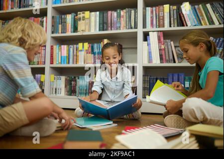 Groupe d'écoliers ayant une leçon de littérature dans la bibliothèque Banque D'Images