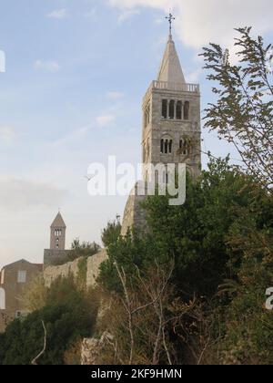 De grands clochers ponctuent la ligne d'horizon sur l'île croate de Rab, où le vieux quartier médiéval et les murs de la ville percent au sommet des falaises. Banque D'Images