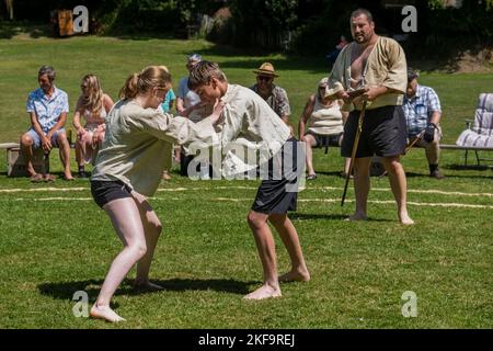 Un juge arbitre Stickler regardant une jeune adolescente se battre avec un garçon en compétition dans le Grand Tournoi de lutte de Cornouailles sur le pittoresque mal Banque D'Images