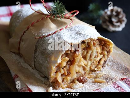 Strudel aux pommes maison avec pâte phyllo, cannelle, sultanines, pignons de pin sur fond rustique. Strudel aux pommes de Noël. Directement au-dessus. Banque D'Images