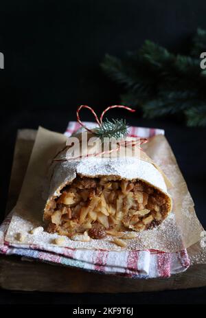 Strudel aux pommes maison avec pâte phyllo, cannelle, sultanines, pignons de pin sur fond rustique. Strudel aux pommes de Noël. Directement au-dessus. Banque D'Images